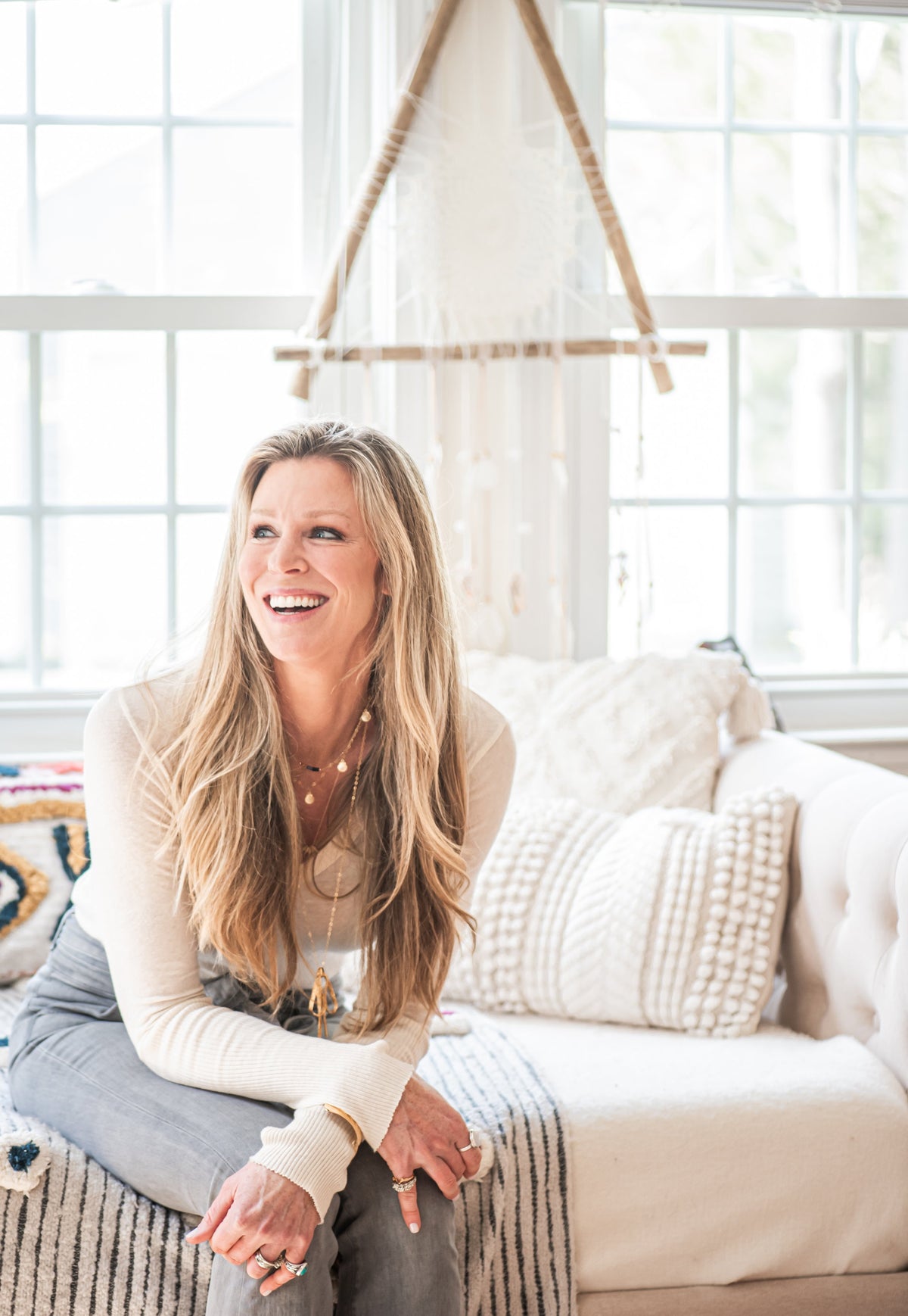 Kerrin Falk laughing, wearing several of her own layered necklaces